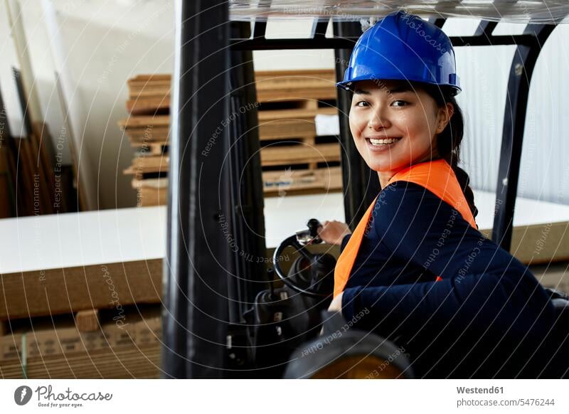 Porträt eines selbstbewussten weiblichen Arbeiters auf einem Gabelstapler in einer Fabrik Portrait Porträts Portraits Fabriken Zuversicht Zuversichtlich