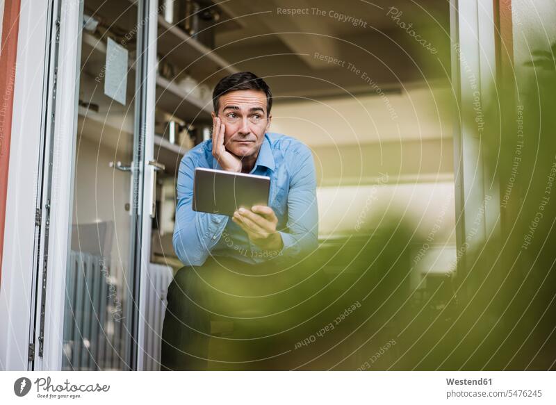 Geschäftsmann mit Tablet sitzen an offenen Französisch Tür Businessmann Businessmänner Geschäftsmänner Fenstertür auf geöffnet sitzend sitzt Tablet Computer