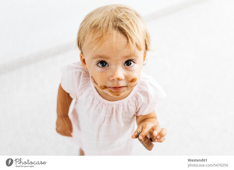 Porträt eines kleinen Mädchens, das einen Schokoladenkeks isst essen essend Schokoladenkekse Schokokeks Schokokekse Portrait Porträts Portraits weibliche Babys