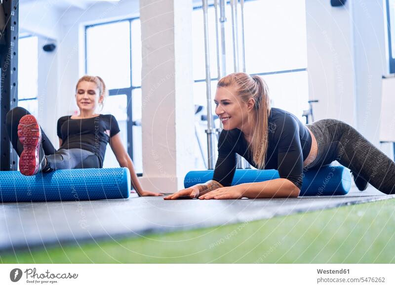 Zwei Frauen massieren nach dem Fitnesstraining Fitnessstudio Fitnessclubs Fitnessstudios Turnhalle Trainerin Übungsleiterinnen Uebungsleiterinnen Trainerinnen