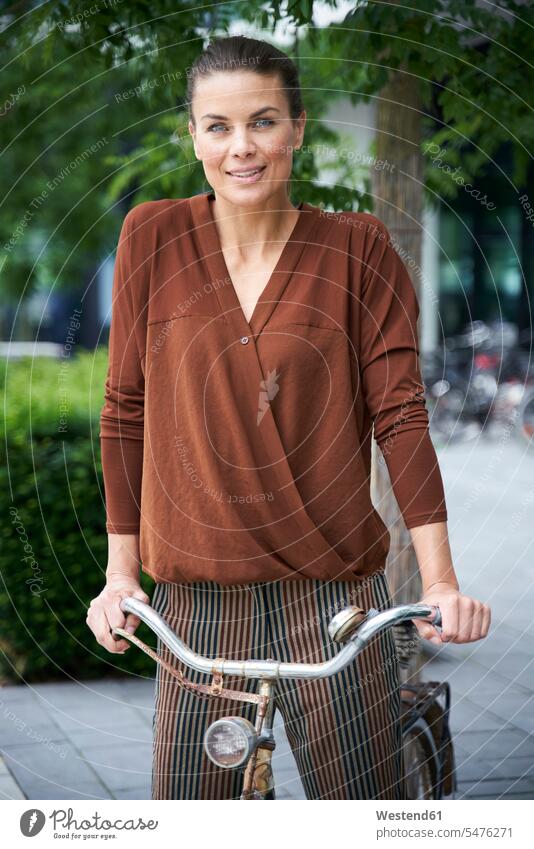 Porträt einer Frau mit Fahrrad in der Stadt geschäftlich Geschäftsleben Geschäftswelt Geschäftsperson Geschäftspersonen Businessfrau Businessfrauen