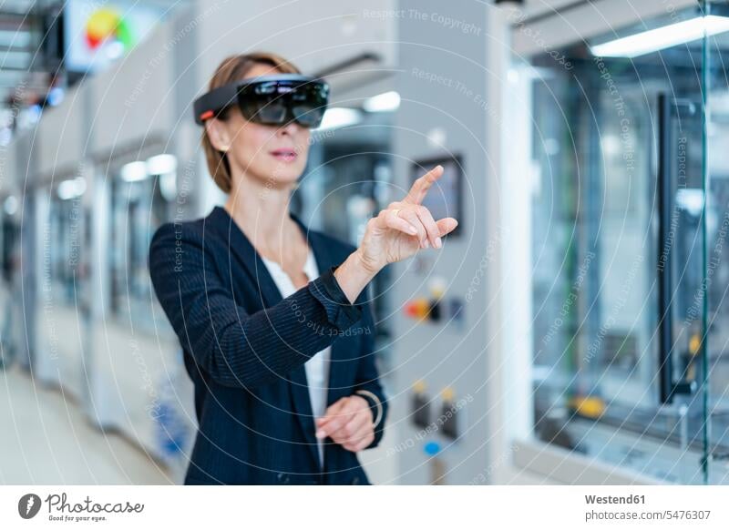 Geschäftsfrau mit AR-Brille in einer modernen Fabrik Job Berufe Berufstätigkeit Beschäftigung Jobs geschäftlich Geschäftsleben Geschäftswelt Geschäftsperson