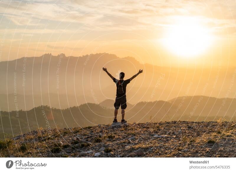 Spanien, Barcelona, Naturpark von Sant Llorenc, Mann wandert und jubelt bei Sonnenuntergang Sonnenuntergänge jubeln jauchzen Jubel wandern Wanderung Männer