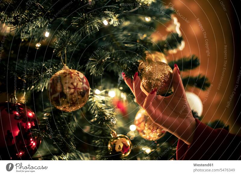 Weibliche Hand hält goldene Christbaumkugel, Nahaufnahme Weihnachten Christmas X-Mas X mas weiblich weibliches weiblicher goldfarben goldfarbene Hände