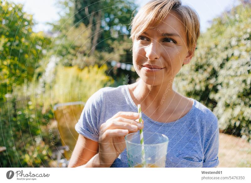 Porträt einer Frau, die im Garten ein Erfrischungsgetränk trinkt trinken Portrait Porträts Portraits Gärten Gaerten Erfrischungsgetraenk Softdrink weiblich