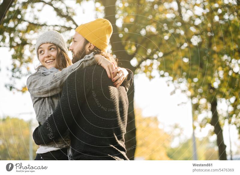 Glückliches junges Paar bei der Umarmung in einem Stadtpark, Berlin, Deutschland Touristen verreisen Arm umlegen Umarmungen Jahreszeiten freuen Frohsinn