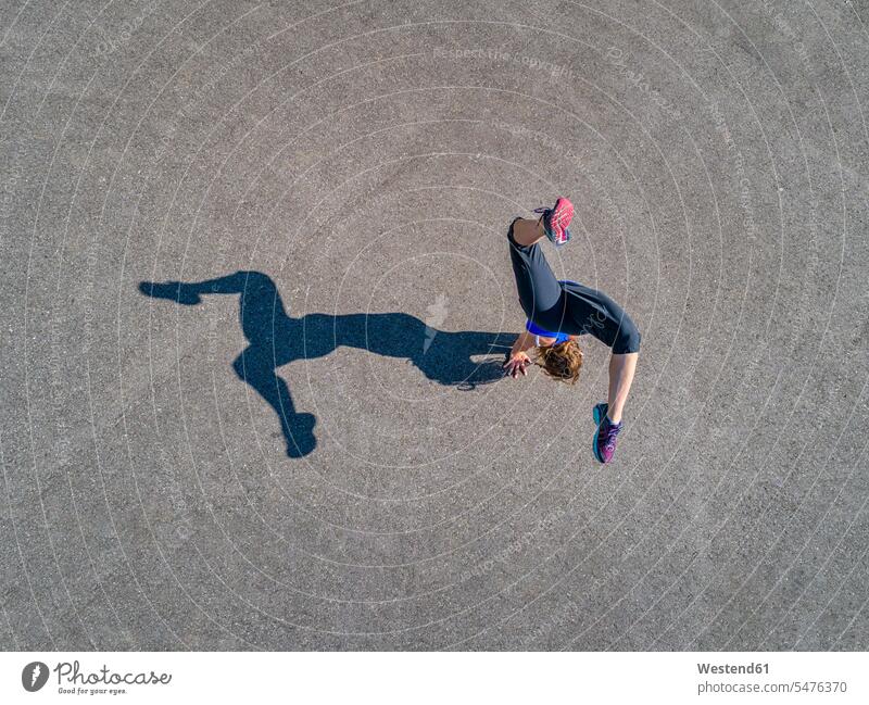 Luftaufnahme einer sportlichen jungen Frau, die Handstand trainiert Luftaufnahmen Vogelperspektive Luftbild Luftbilder trainieren kopfüber auf dem Kopf