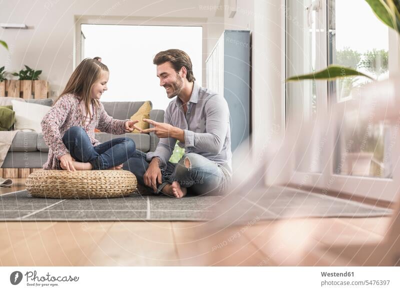 Junger Mann und kleines Mädchen sitzen zu Hause, spielen Papier Schere Stein optimistisch Optimismus Schere Stein Papier Schnick Schnack Schnuck