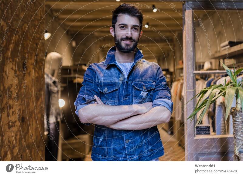 Porträt eines lächelnden Mannes mit Jeansjacke in einem Herrenbekleidungsgeschäft Kunde Kunden Kundschaft Geschäft Shop Laden Läden Geschäfte Shops Herrenmode