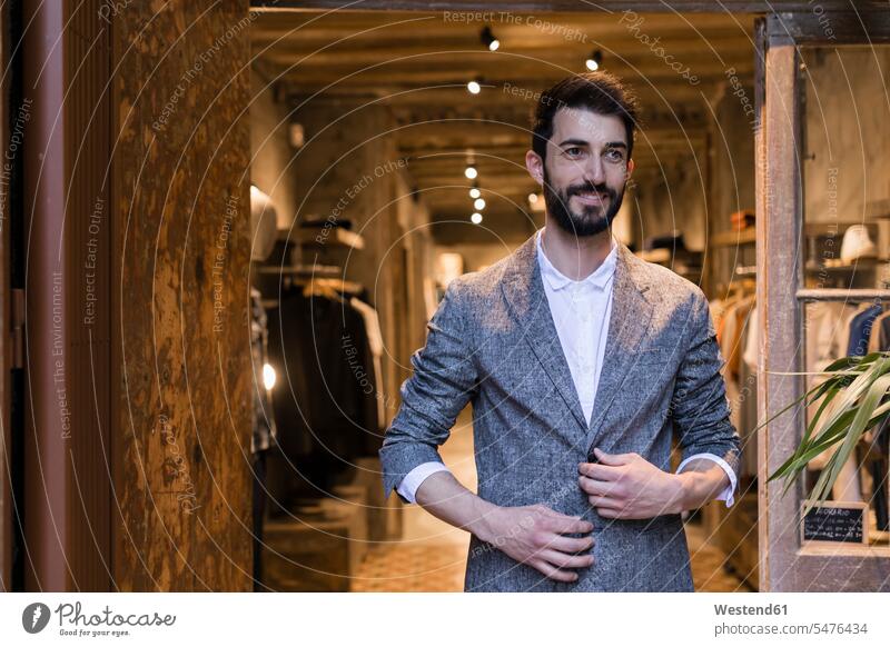 Porträt eines lächelnden Mannes in Jacke beim Verlassen eines Herrenbekleidungsgeschäfts Kunde Kunden Kundschaft verlassen Herrenmode Männer männlich Portrait