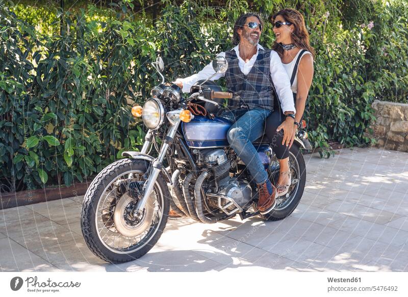 Glückliches reifes Paar auf einem Oldtimer-Motorrad Hecken Transport Transportwesen KFZ Verkehrsmittel Motorräder Brillen Sonnenbrillen entspannen relaxen