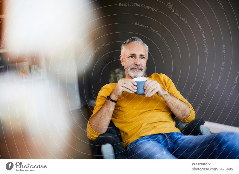 Entspannter reifer Mann zu Hause bei einer Tasse Kaffee Leute Menschen People Person Personen Alleinstehende Alleinstehender Singles Unverheiratete