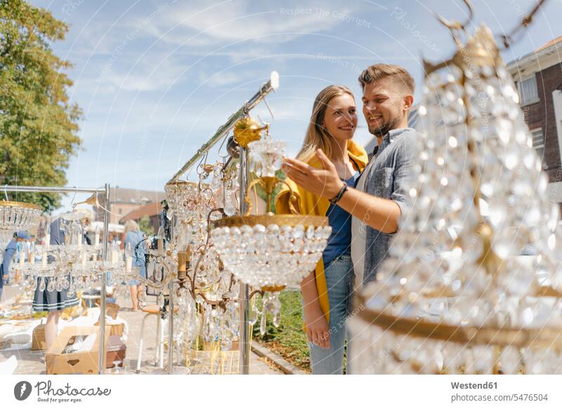 Belgien, Tongeren, lächelndes junges Paar auf einem Antiquitätenflohmarkt Antiquitaeten Pärchen Paare Partnerschaft Trödelmarkt Flohmärkte Flohmaerkte
