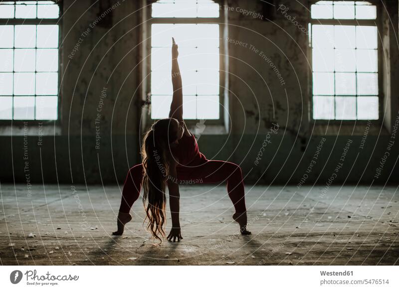 Sportler übt Yoga-Position in verlassener Fabrik Farbaufnahme Farbe Farbfoto Farbphoto Innenaufnahme Innenaufnahmen innen drinnen Sportkleidung Sportbekleidung