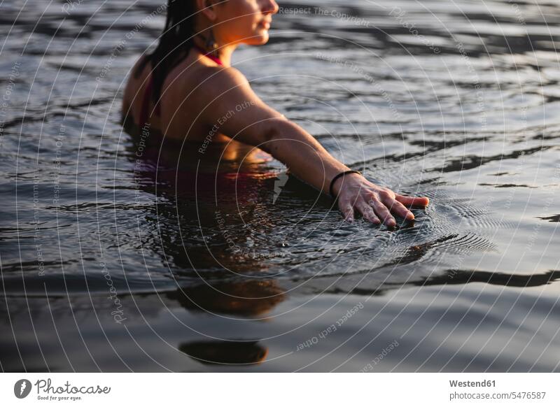 Hand einer jungen Frau berührt die Wasseroberfläche in einem See Seen berühren Berührung anfassen Hände fühlen weiblich Frauen Gewässer Mensch Menschen Leute