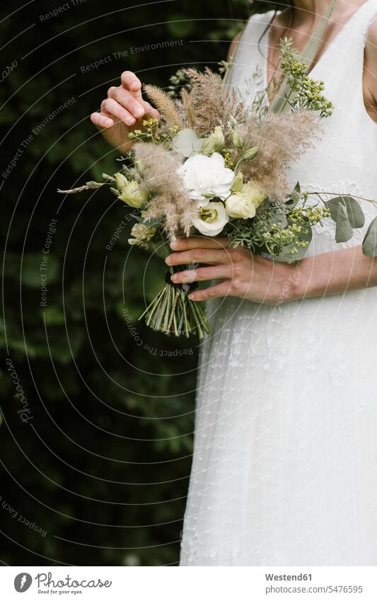Junge Frau in elegantem Brautkleid hält Blumenstrauss Freisteller freigestellt Serie Serien Studioaufnahme Innenaufnahme innen Vorderansicht Frontalansicht