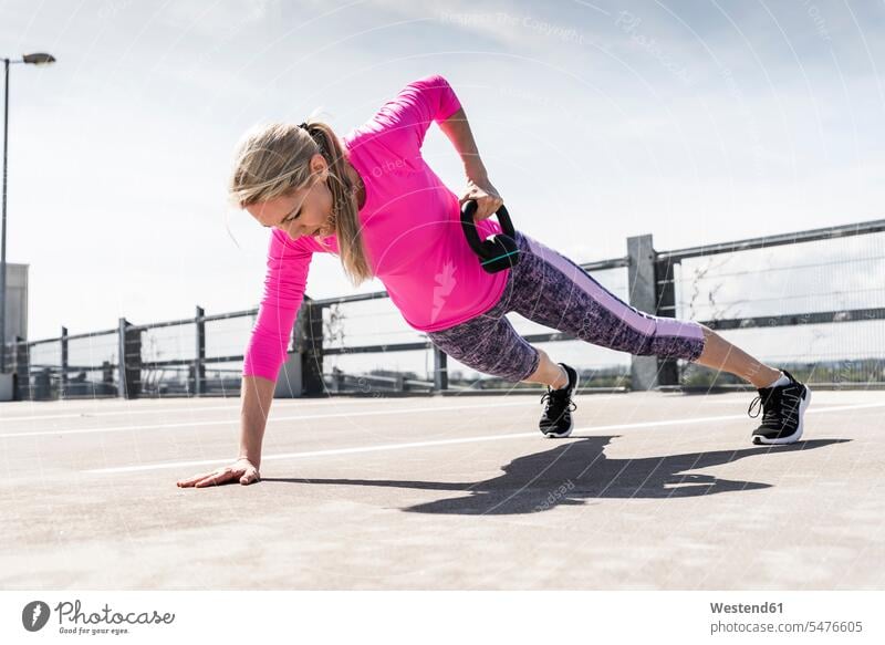 Frau trainiert mit Kurzhanteln, macht einarmige Planke Sportler Workout Krafttraining trainieren stark Stärke kräftig sportlich fit Hantel Hanteln Sportlerin