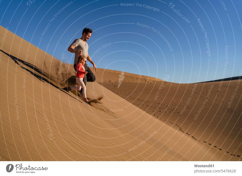 Vater und Tochter laufen eine Sanddüne hinunter, Gran Canaria, Spanien Touristen entspannen relaxen rennen entspanntheit relaxt freuen Frohsinn Fröhlichkeit