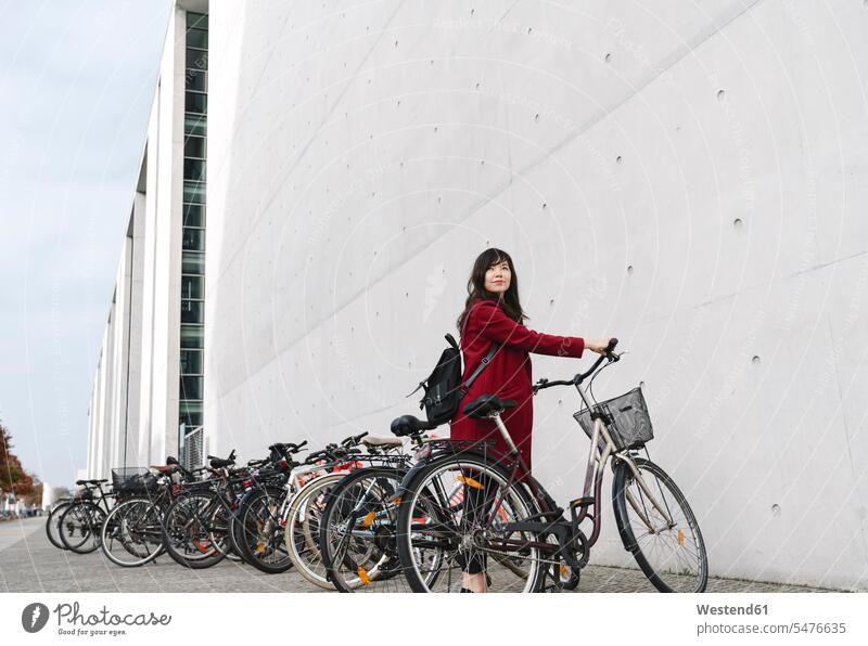 Geschäftsfrau mit Fahrrad im Hintergrund des modernen Gebäudes geschäftlich Geschäftsleben Geschäftswelt Geschäftsperson Geschäftspersonen Businessfrau