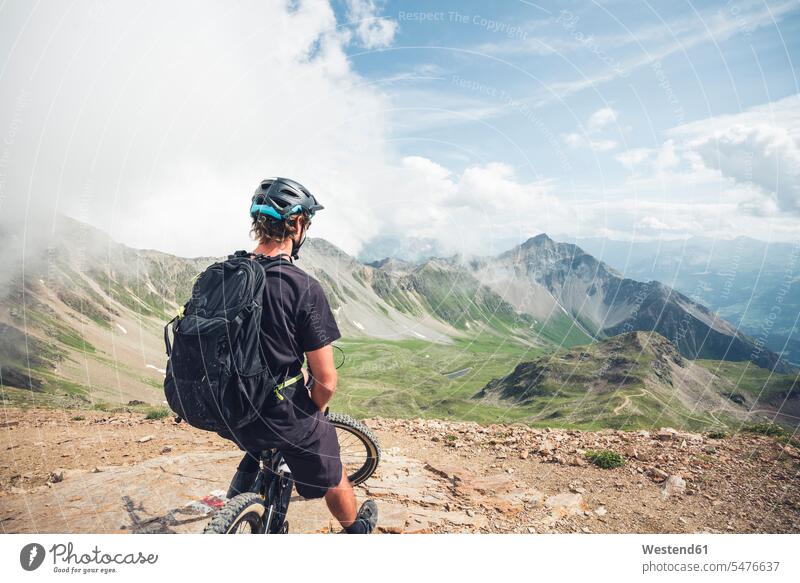 Mountainbiker am Aussichtspunkt auf der Lenzerheide in Graubünden, Schweiz Rucksäcke Raeder Räder Bike Bikes Fahrräder Rad stehend steht Muße mountainbiken MTB