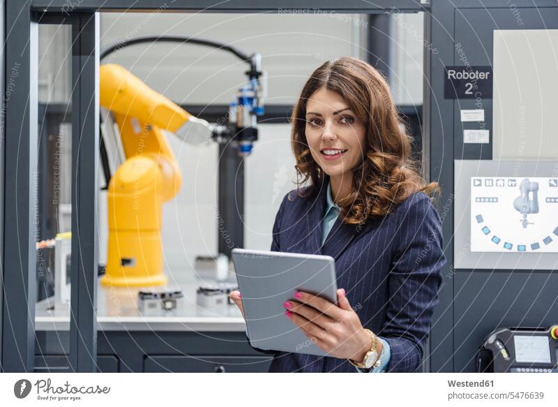Geschäftsfrau, die in einem Hightech-Unternehmen arbeitet und ein digitales Tablet benutzt Industrie industriell Gewerbe Industrien Roboter Geschäftsfrauen