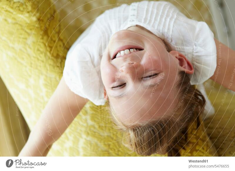 Porträt eines glücklichen Mädchens auf einer Couch liegend freuen Frohsinn Fröhlichkeit Heiterkeit geniessen Genuss Glück glücklich sein glücklichsein