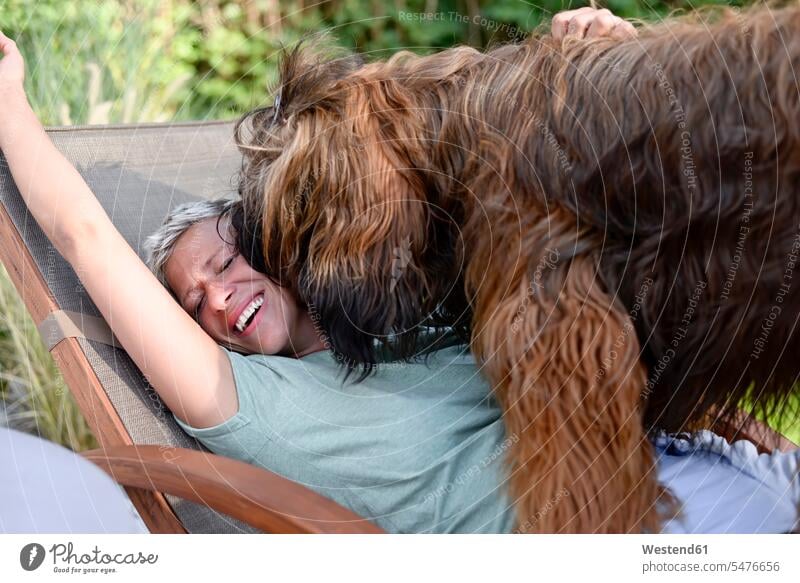 Lachende Frau hat Spaß mit ihrem Hund im Garten Hunde Gärten Gaerten lachen weiblich Frauen Haustier Haustiere Tier Tierwelt Tiere positiv Emotion Gefühl