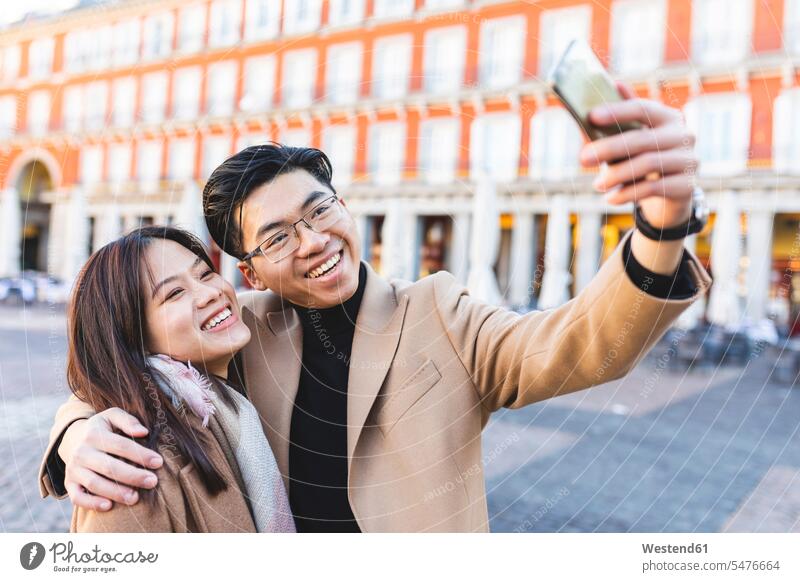 Spanien, Madrid, glückliches junges Paar macht ein Selfie in der Stadt staedtisch städtisch Selfies Glück glücklich sein glücklichsein Pärchen Paare