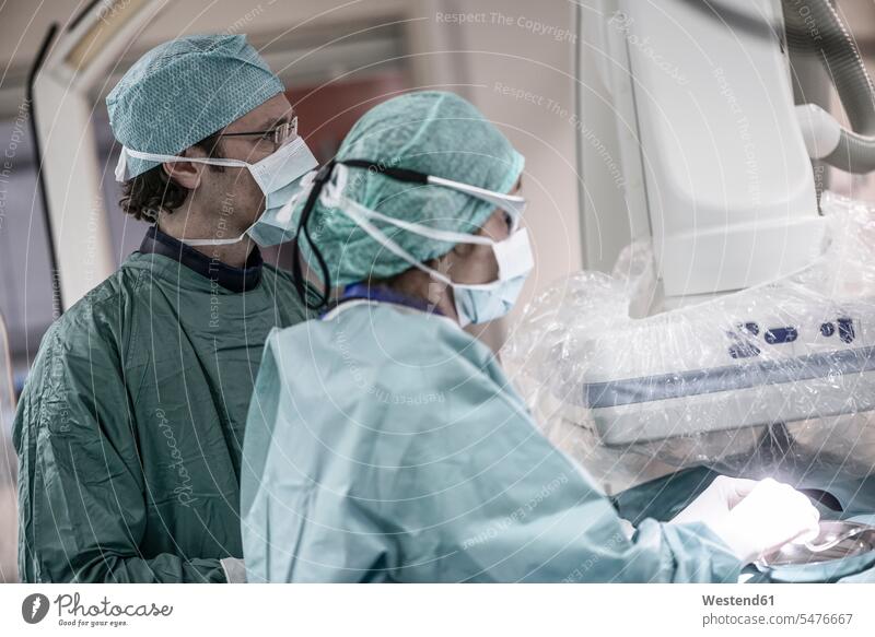 Neuroradiologe mit Assistent im Kittel Assistentin Arzt Doktoren Ärzte Operation OP Operationen operieren Chirurgie Krankenhaus Kliniken Krankenhäuser