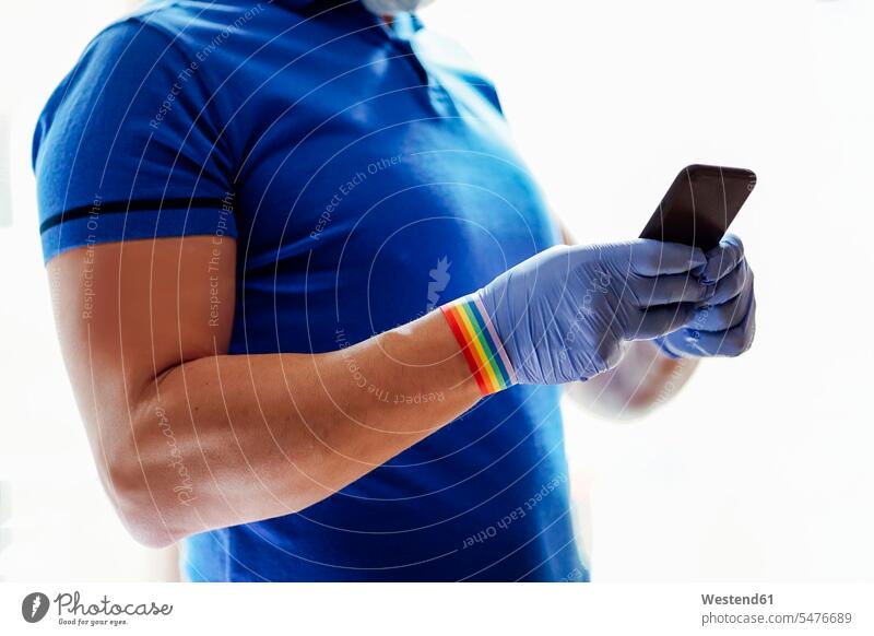 Arzt mit Gesichtsmaske, mit Smartphone Informationen Telekommunikation telefonieren Handies Handys Mobiltelefon Mobiltelefone Lektüre Farben Farbtoene Farbton