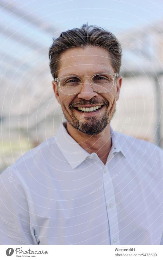 Nahaufnahme eines lächelnden männlichen Berufstätigen mit Brille in der Gärtnerei Farbaufnahme Farbe Farbfoto Farbphoto Deutschland Geschäftsleute
