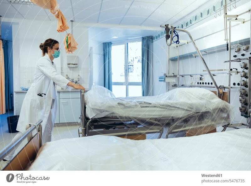 Arzt im Krankenhauszimmer schiebt Betten Job Berufe Berufstätigkeit Beschäftigung Jobs Brillen Arbeit Gesundheit Gesundheitswesen medizinisch geschützt schützen