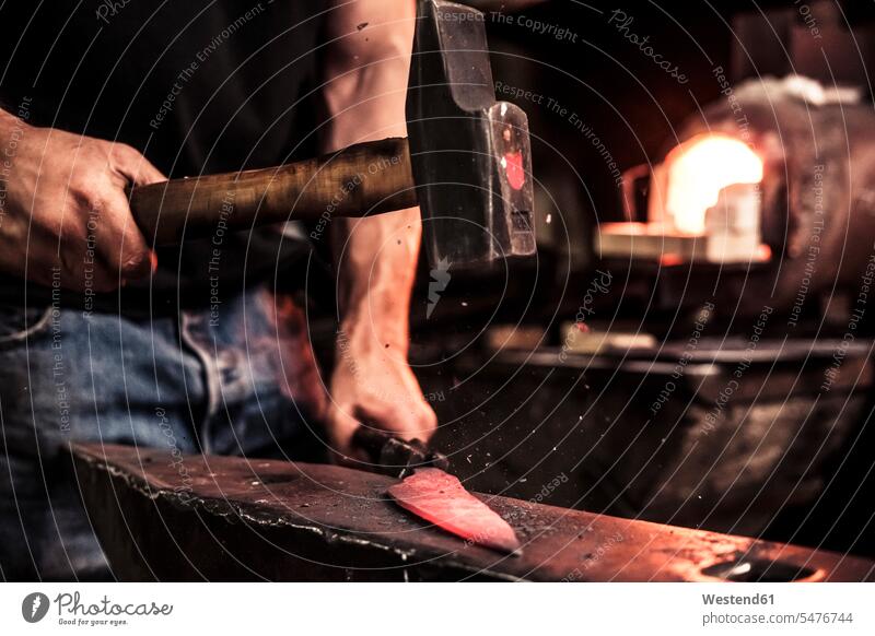 Messermacher bei der Arbeit, Stahlsplitter beim Hämmern von Damaststahl Leute Menschen People Person Personen Europäisch Kaukasier kaukasisch 1 Ein ein Mensch