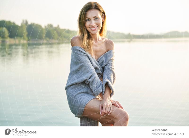 Porträt einer reifen Frau, die auf einer Stange an einem See sitzt Leute Menschen People Person Personen Europäisch Kaukasier kaukasisch 1 Ein ein Mensch