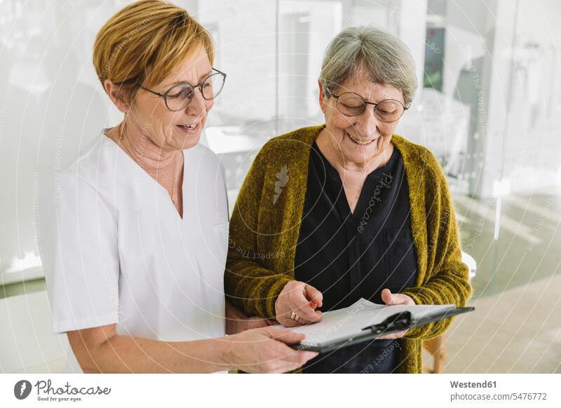 Medizinische Sekretärin hilft älterem Patienten beim Ausfüllen des Dokuments Gesundheit Gesundheitswesen medizinisch Erkrankung Erkrankungen Krankheiten Kranke