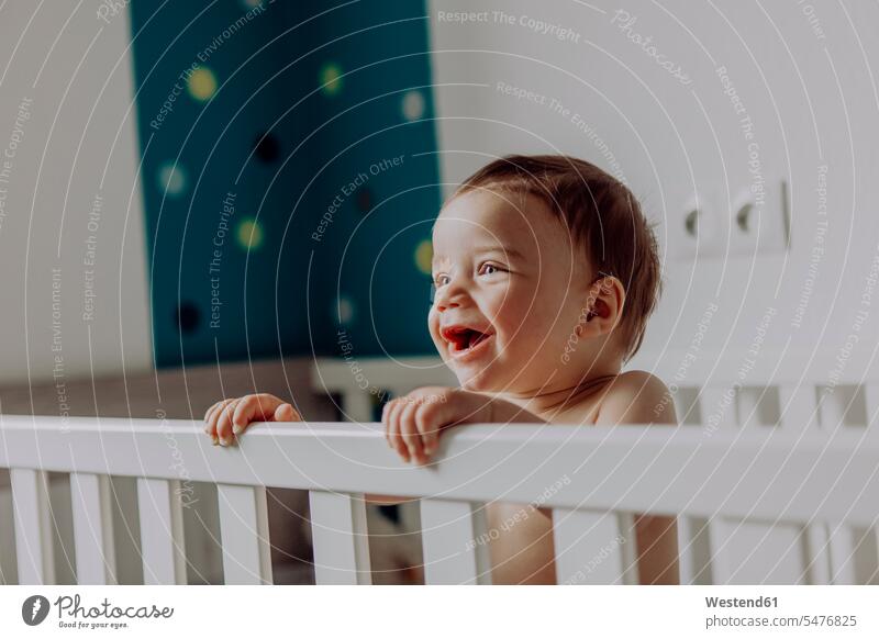 Kleiner Junge steht in seinem Bettchen und lacht stehen stehend Betten Kinderbett Kinderbetten Baby Babies Babys Säuglinge lachen Mensch Menschen Leute People