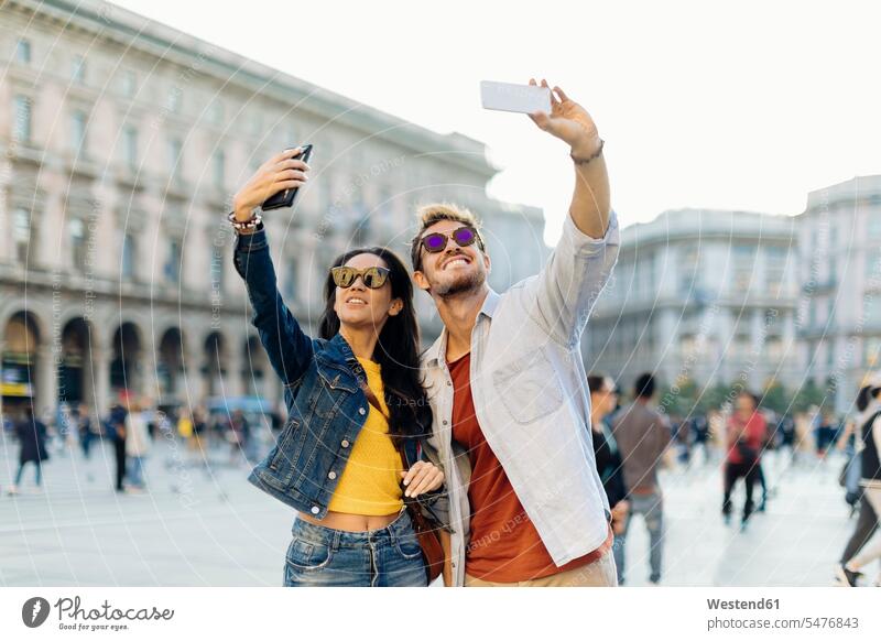 Glückliches junges Paar macht Selfies in der Stadt, Mailand, Italien Touristen Telekommunikation telefonieren Handies Handys Mobiltelefon Mobiltelefone Brillen