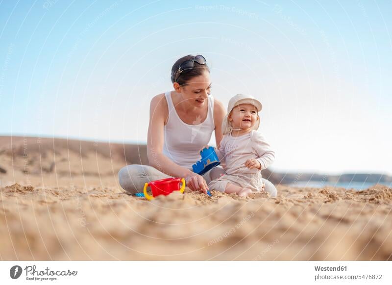 Mutter spielt mit kleiner Tochter am Strand Baby Babies Babys Säuglinge Kind Kinder Töchter spielen Mami Mutti Mütter Mama Beach Straende Strände Beaches Mensch