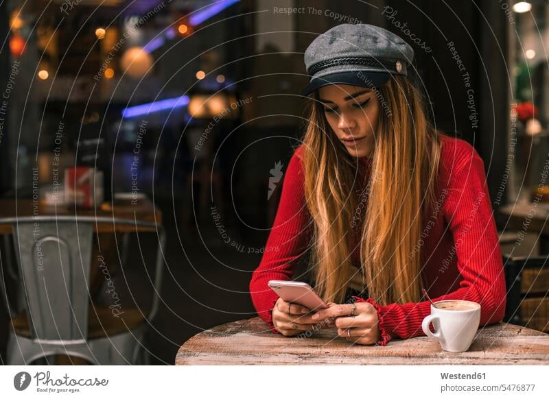 Porträt der jungen Frau Text-Messaging auf der Terrasse eines Cafés weiblich Frauen Portrait Porträts Portraits Coffee Shop Coffee Shops SMS Textnachricht