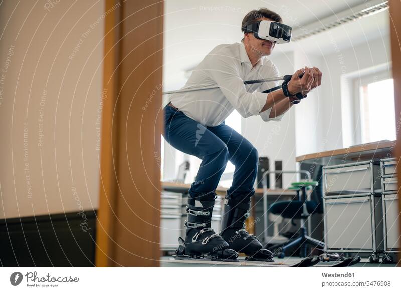 Geschäftsmann beim Skifahren im Büro, mit VR-Brille Businessmann Businessmänner Geschäftsmänner Virtual Reality Virtuelle Realität Office Büros