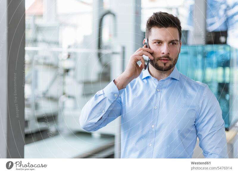 Porträt eines Mannes mit Mobiltelefon in der Fabrik Fabriken Portrait Porträts Portraits telefonieren anrufen Anruf telephonieren Männer männlich Handy Handies