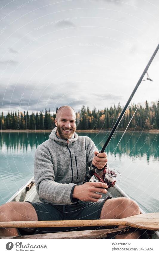 Kanada, Britisch-Kolumbien, Porträt eines glücklichen Mannes beim Fischen im Kanu auf dem Boya-See Glück glücklich sein glücklichsein Kanus Portrait Porträts