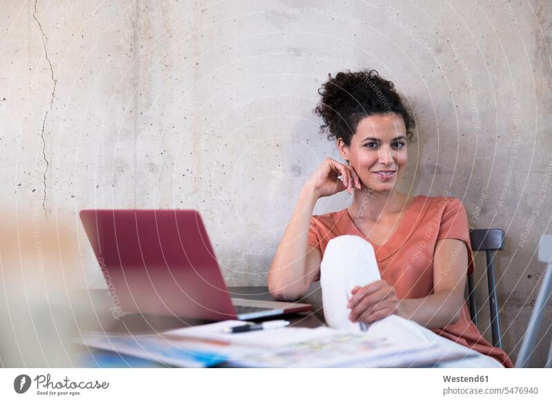 Porträt der lächelnden Geschäftsfrau sitzt am Tisch mit Dokumenten und Laptop Notebook Laptops Notebooks Tische Unterlagen sitzen sitzend Portrait Porträts