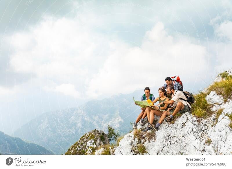 Italien, Massa, Gruppe von Menschen wandern und Blick auf eine Karte in den Alpi Apuane Wanderung Landkarte Landkarten sitzen sitzend sitzt Berg Berge Gebirge