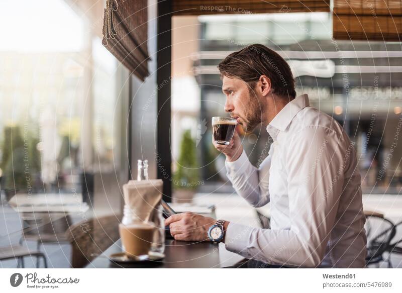 Geschäftsmann mit Tablet in einem Café trinken Kaffee aus Glas Businessmann Businessmänner Geschäftsmänner Cafe Kaffeehaus Bistro Cafes Cafés Kaffeehäuser