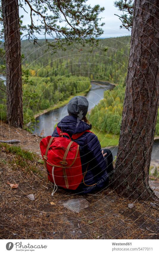 Finnland, Oulanka National Park, Frau mit Rucksack sitzt in unberührter Natur sitzen sitzend weiblich Frauen Erwachsener erwachsen Mensch Menschen Leute People
