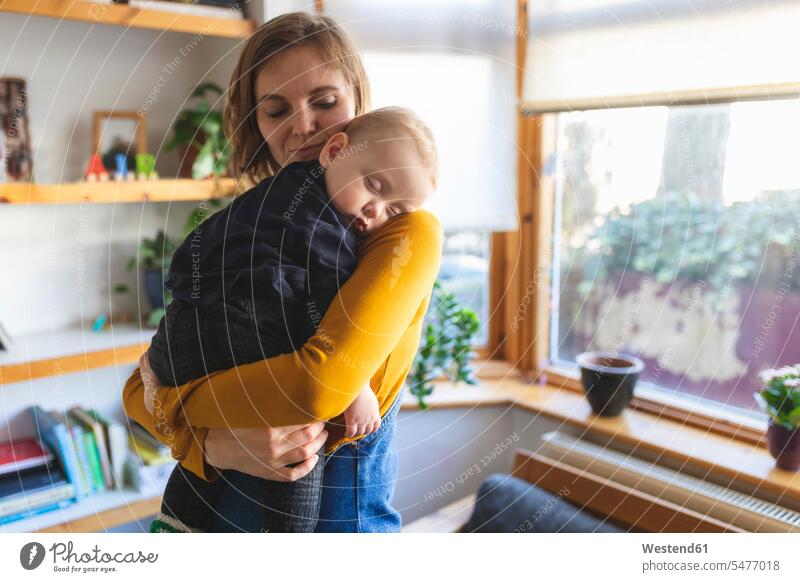 Mutter hält ihren schlafenden Sohn auf der Schulter entspannen relaxen knuddeln schmusen Arm umlegen Umarmung Umarmungen behüten behütet geborgen Sicherheit