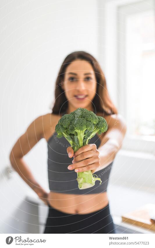 Frau hält einen Brokkoli Broccoli Winterblumenkohl Sprossenkohl halten weiblich Frauen Kohl Gemüsekohl Gemuese Essen Food Food and Drink Lebensmittel