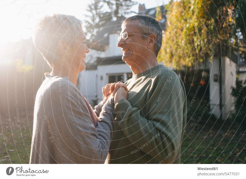 Glückliches zärtliches älteres Paar, das sich im Garten an den Händen hält Zuneigung glücklich glücklich sein glücklichsein Pärchen Paare Partnerschaft
