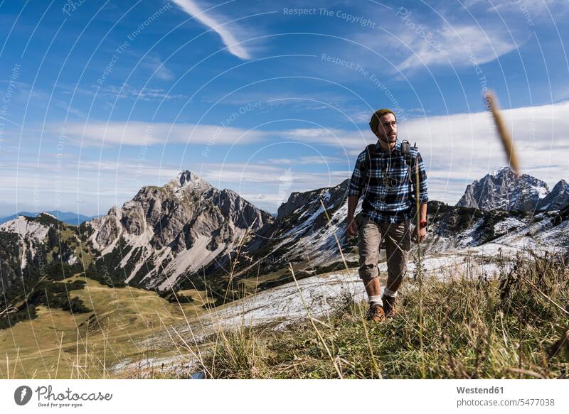 Österreich, Tirol, junger Mann wandert in den Bergen Männer männlich Gebirge Berglandschaft Gebirgslandschaft Gebirgskette Gebirgszug wandern Wanderung